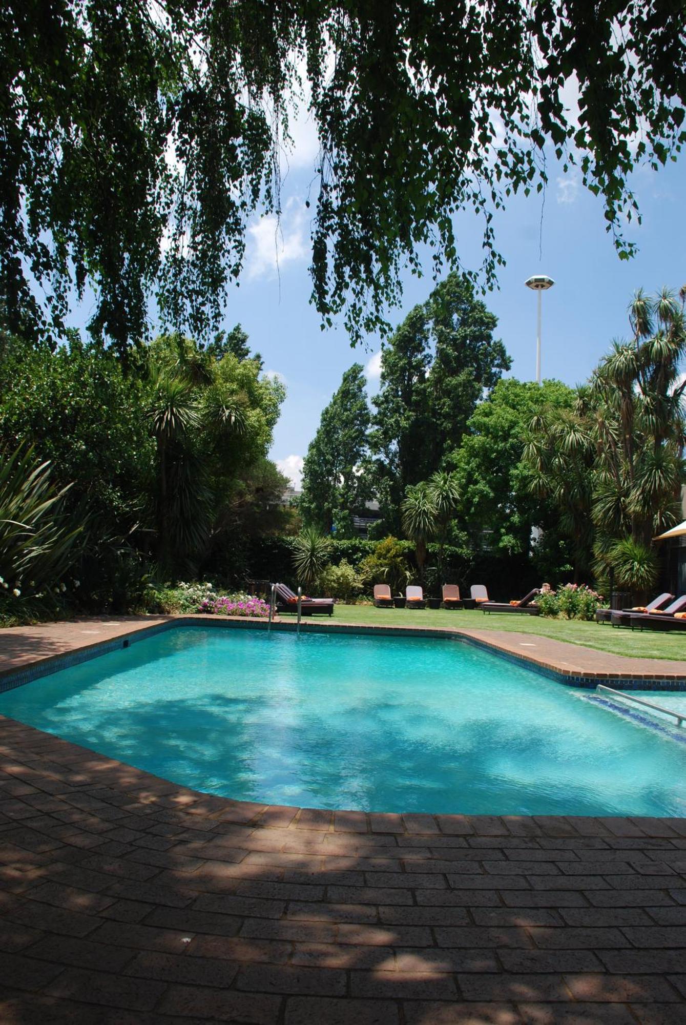 Southern Sun Or Tambo International Airport Kempton Park Eksteriør billede The garden and swimming pool at the residence